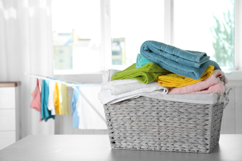 Basket with clean laundry on table at home