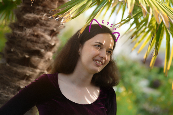 A portrait: I'm a woman with dark hair, I'm smiling and cat's ear are drawn on top of my head