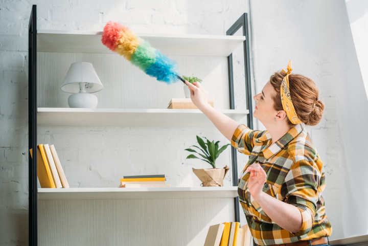 Deep cleaning house checklist : A woman cleaning the top of a shelf