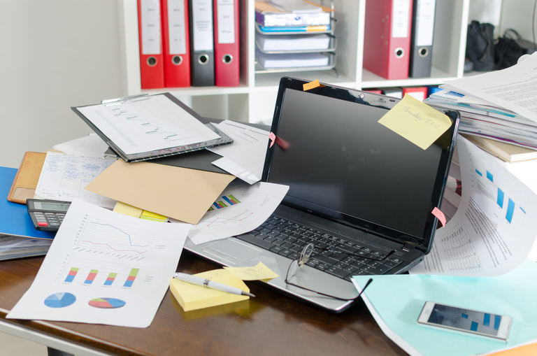A cluttered desk in a messy office