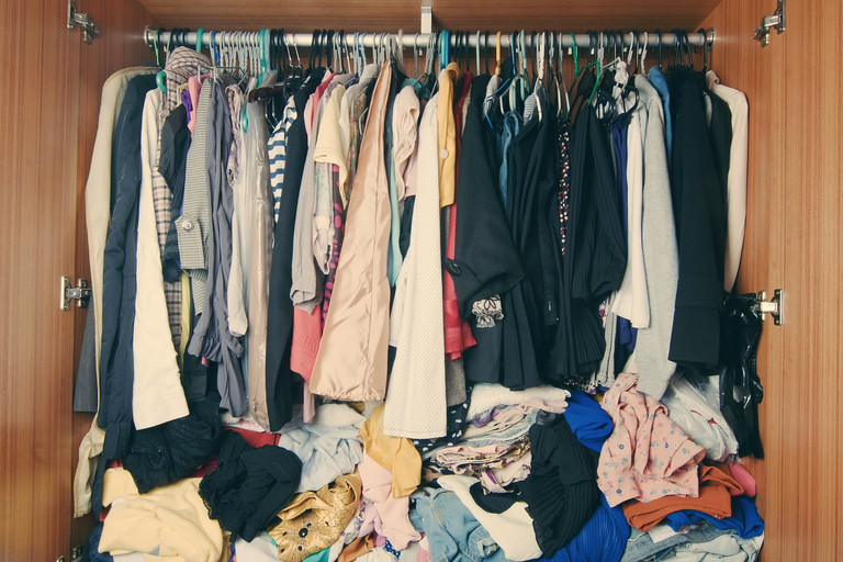 A messy closet cluttered by clothes