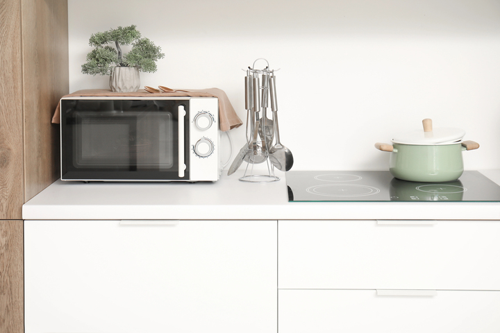 A microwave on a kitchen counter near a cooktop